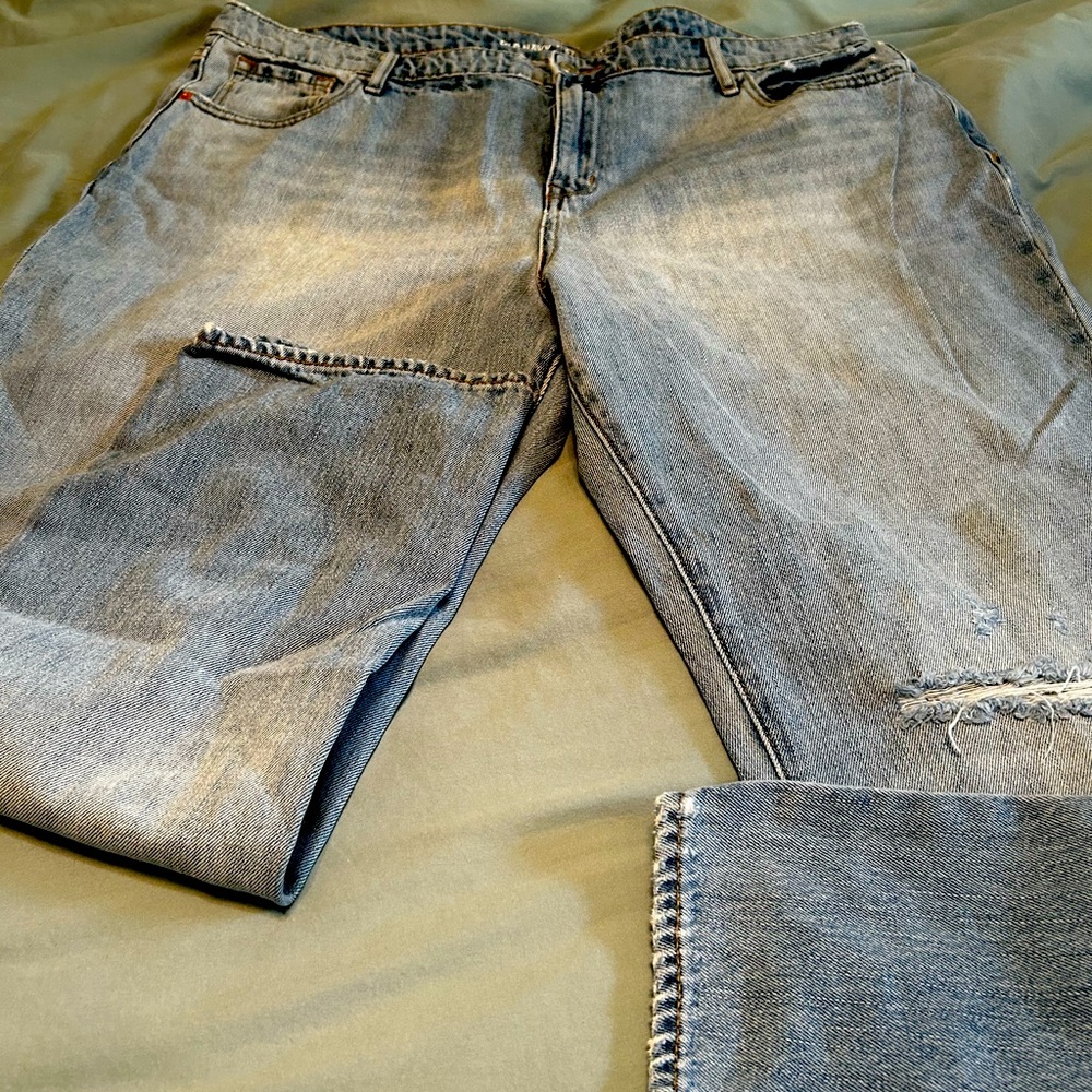 Light wash straight jeans, one deconstructed knee